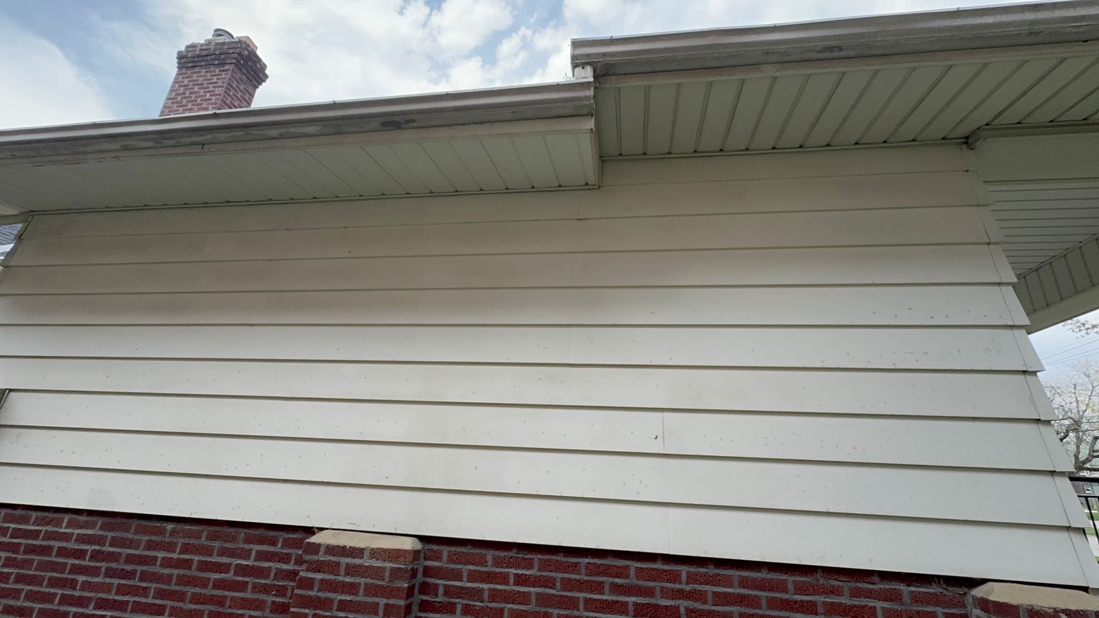 White fascia and gutters dingy over brick before cleaning